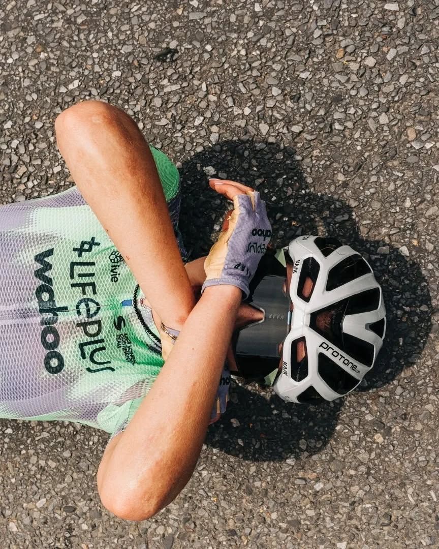 Rider resting on the tarmac after a hard effort
